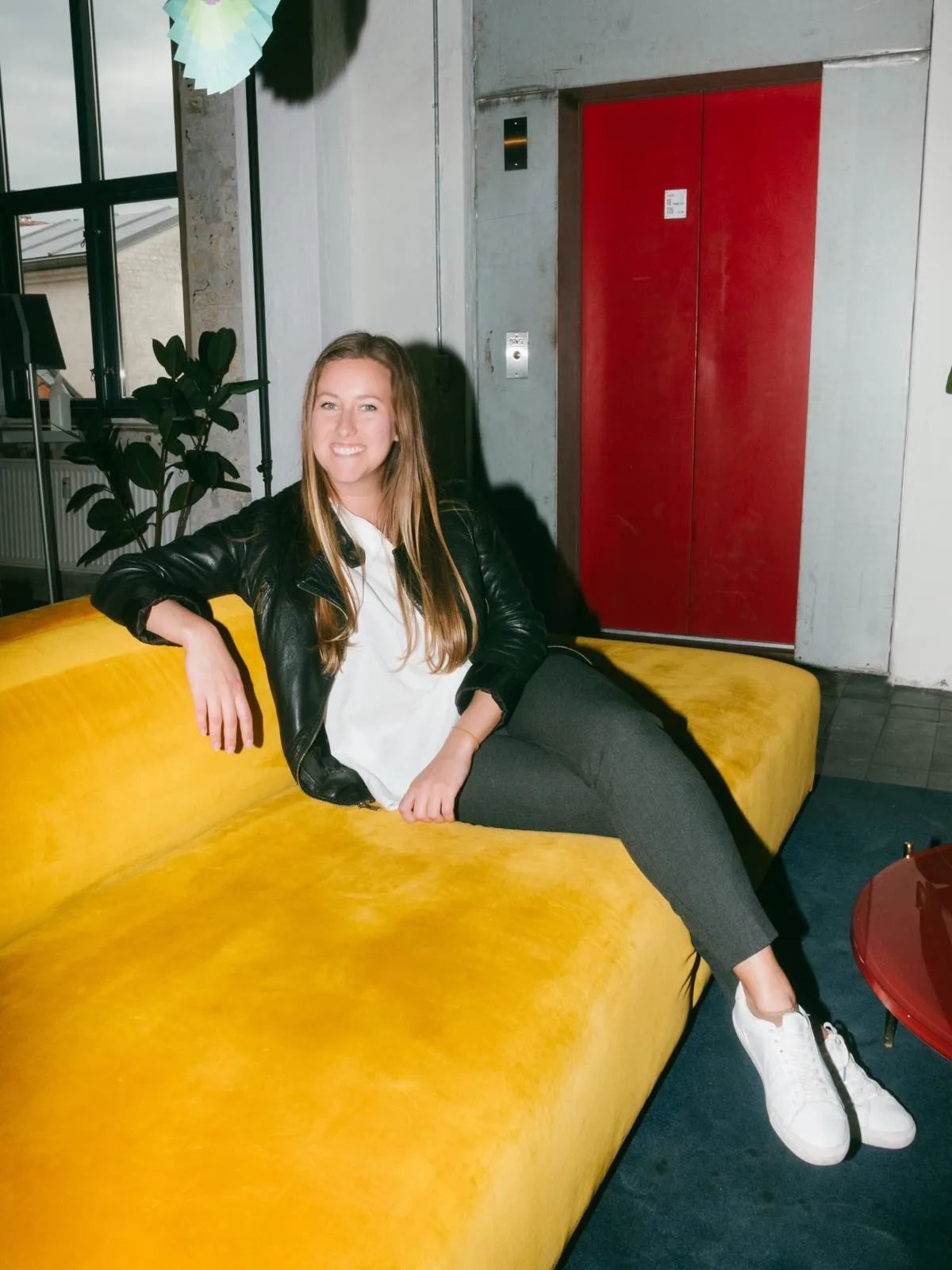Sheli Efimova sitting on a yellow velvet sofa